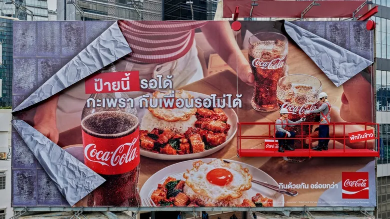 งานยังไม่เสร็จ แต่พักกินข้าวก่อนได้ไหม? โคคา-โคล่า ทิ้งปริศนาแคมเปญใหม่ผ่านป้ายโฆษณาที่ยัง "ทำไม่เสร็จ"